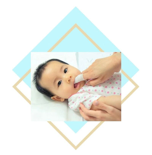 Baby receiving gentle dental care with soft cloth on finger for oral hygiene